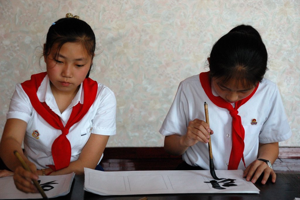 Des élèves au Palais des enfants de Pyongyang faisant de la calligraphie