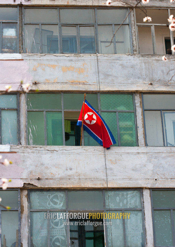 Le drapeau Nord-coréen à la fenêtre d'un vieil immeuble décrépit
