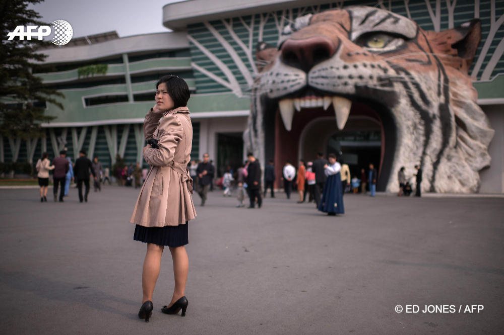 Une femme se tient devant l'entrée du zoo de Pyongyang, Corée du Nord