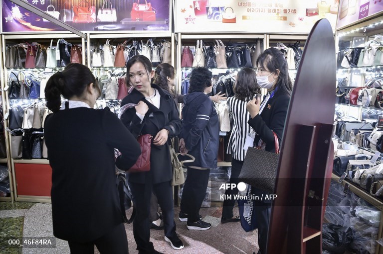 Des clients essaient des sacs à main lors de la 23e Foire Commerciale Internationale de Printemps de Pyongyang